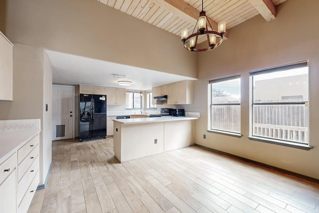 kitchen with beam ceiling, light countertops, black refrigerator with ice dispenser, an inviting chandelier, and a peninsula