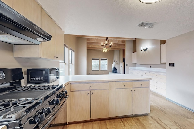 kitchen featuring black microwave, extractor fan, light brown cabinets, a peninsula, and stainless steel gas range