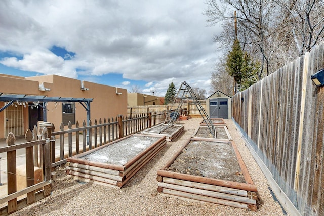 view of yard featuring an outbuilding, a shed, a fenced backyard, and a garden