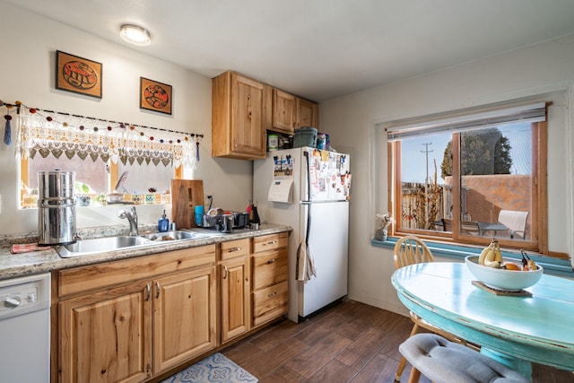 kitchen with light countertops, white appliances, dark wood-type flooring, and a sink