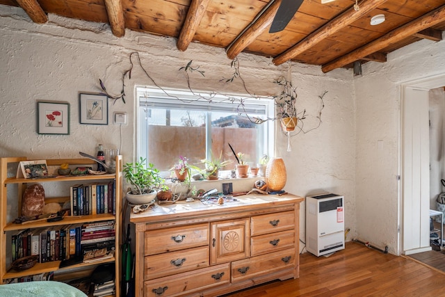 interior space featuring a textured wall, wooden ceiling, beamed ceiling, and wood finished floors