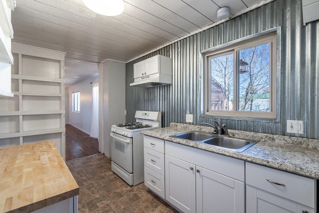 kitchen with a wealth of natural light, under cabinet range hood, a sink, and white gas stove