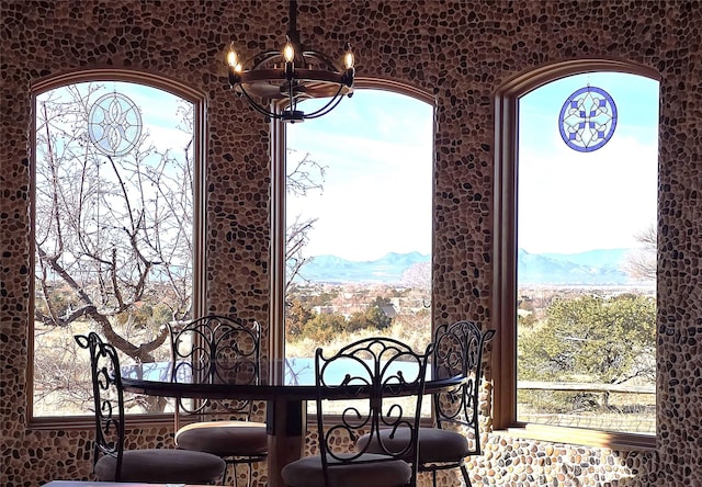 dining space with a mountain view and a notable chandelier