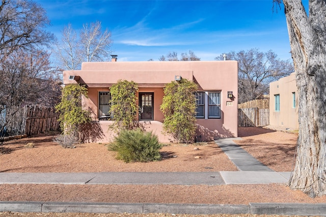 adobe home with fence and stucco siding