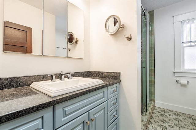 bathroom featuring baseboards, walk in shower, and vanity