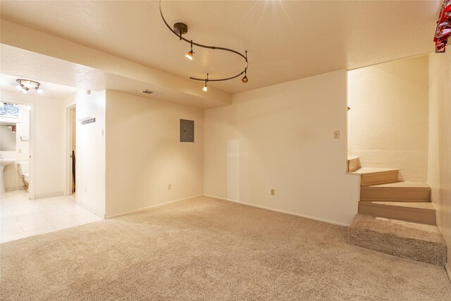 empty room featuring light tile patterned floors, electric panel, visible vents, light colored carpet, and stairway