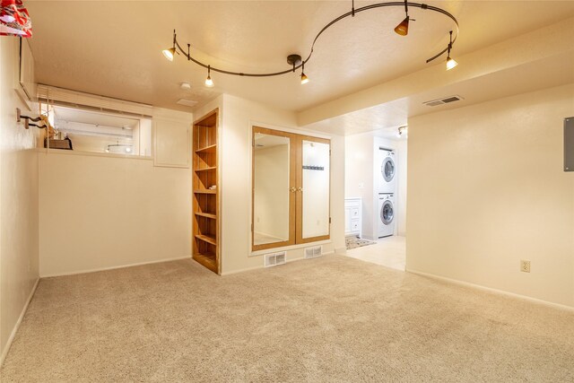 interior space featuring stacked washer / dryer, visible vents, and carpet flooring