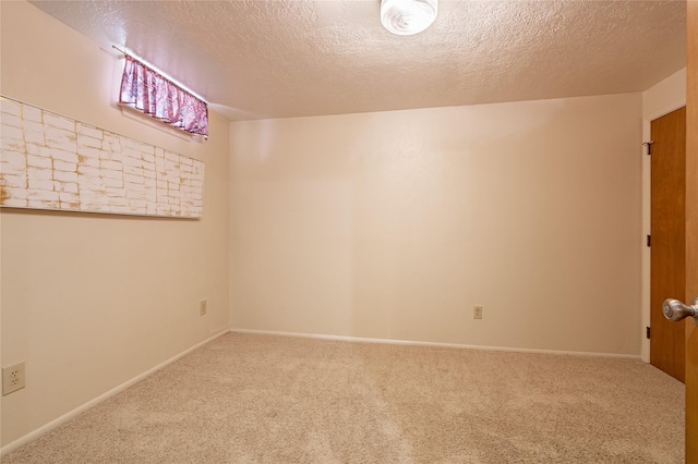 unfurnished room with a textured ceiling, carpet floors, and baseboards