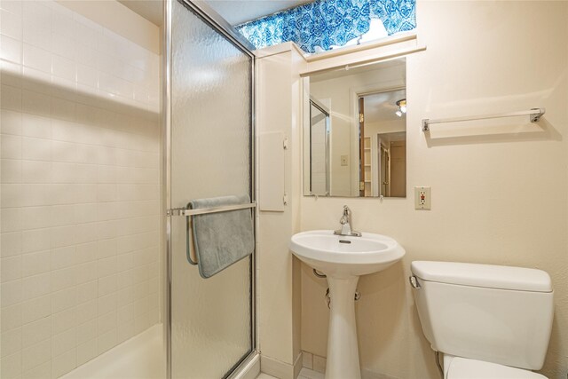 bathroom with a shower stall and toilet