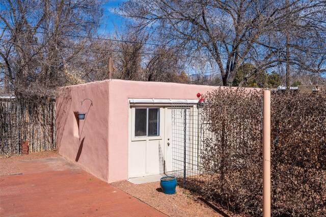 view of outdoor structure with fence and an outbuilding