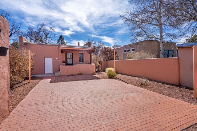 view of front of property with stucco siding, a gate, and a fenced front yard