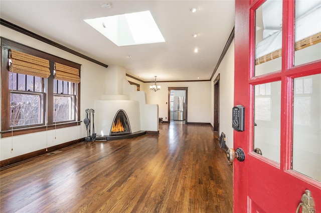 unfurnished living room with baseboards, visible vents, ornamental molding, wood finished floors, and a fireplace