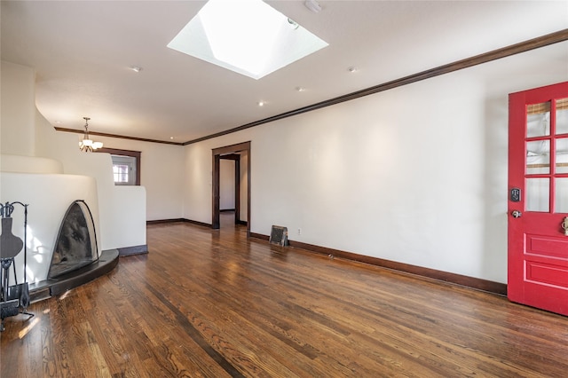 living room with an inviting chandelier, crown molding, baseboards, and wood finished floors