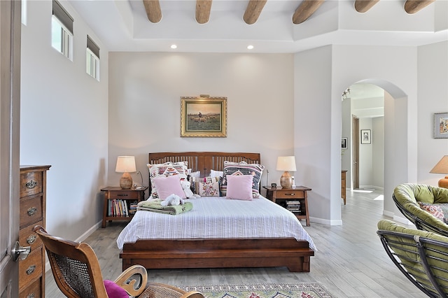 bedroom featuring recessed lighting, baseboards, arched walkways, and light wood-style floors