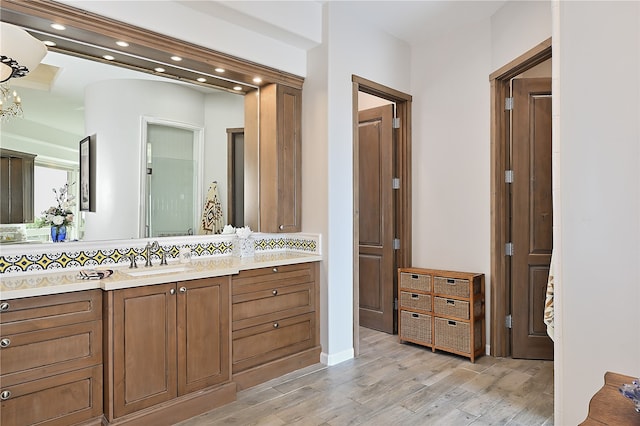 full bathroom featuring vanity, wood finished floors, recessed lighting, backsplash, and a chandelier