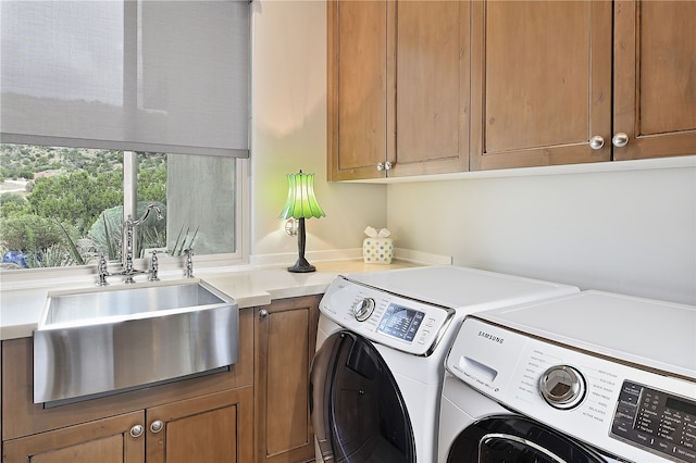 laundry room with cabinet space, independent washer and dryer, and a sink