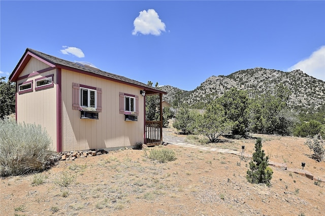 view of side of home with a mountain view and an outbuilding