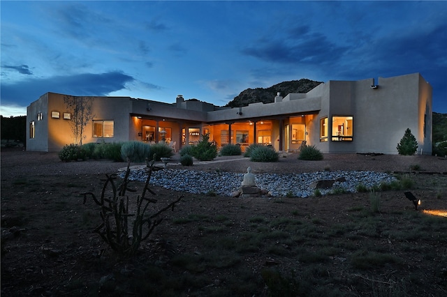 rear view of property featuring stucco siding