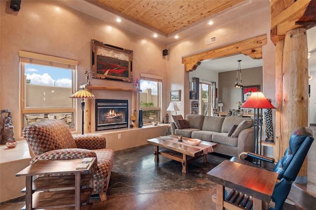 living area with visible vents, a glass covered fireplace, recessed lighting, wood ceiling, and a towering ceiling