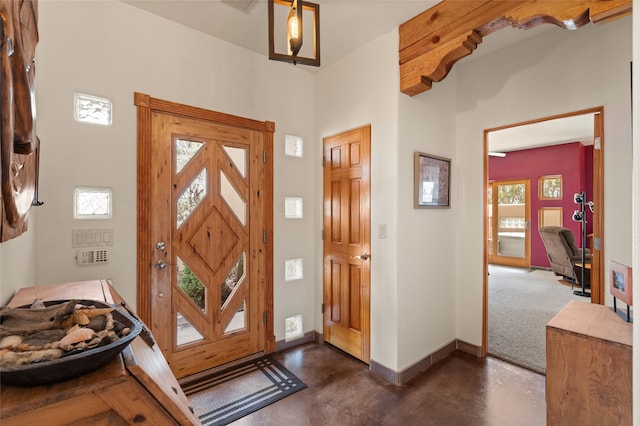 entrance foyer featuring concrete floors and baseboards