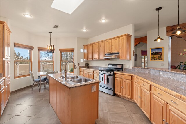 kitchen with visible vents, a skylight, a sink, under cabinet range hood, and gas range