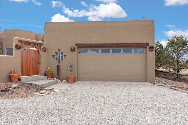 garage featuring gravel driveway and a gate