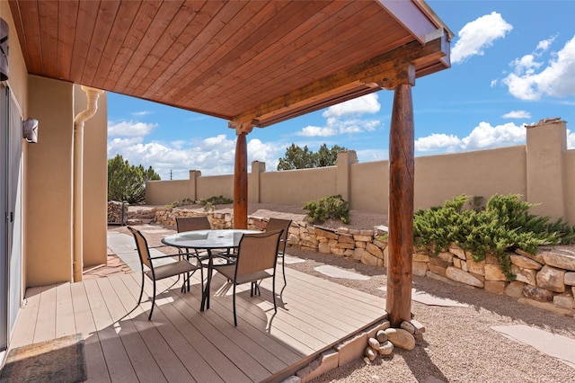 wooden terrace featuring outdoor dining area and a fenced backyard