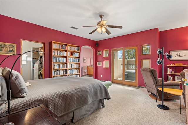 carpeted bedroom with access to outside, visible vents, arched walkways, and ceiling fan