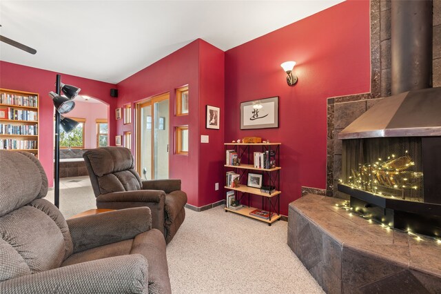 living area with arched walkways, carpet, and a ceiling fan