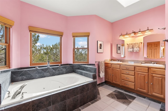 bathroom featuring double vanity, a tub with jets, tile patterned floors, and a sink