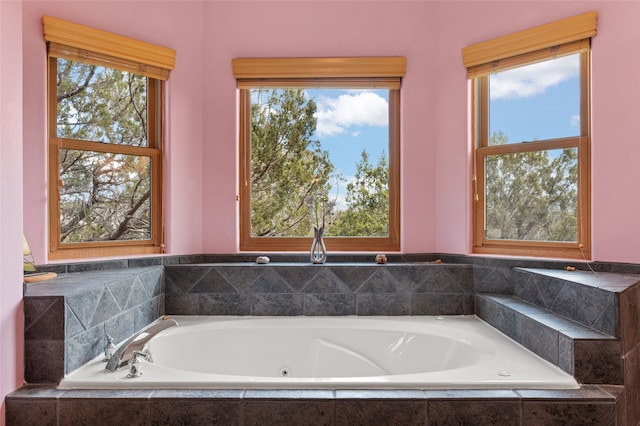 full bath with a garden tub and a healthy amount of sunlight