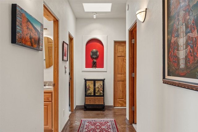 hall with baseboards and a skylight