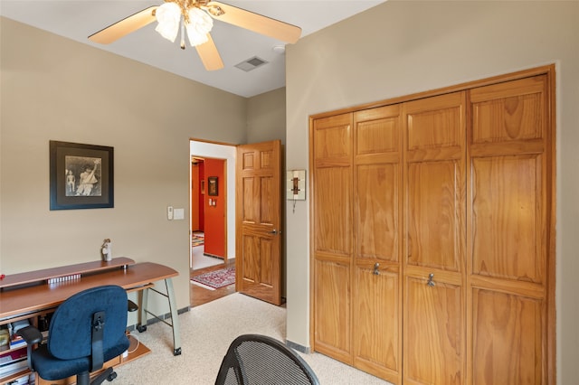 office space with visible vents, carpet floors, and ceiling fan