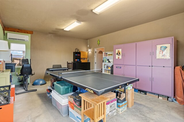 game room featuring a wall mounted air conditioner and concrete floors