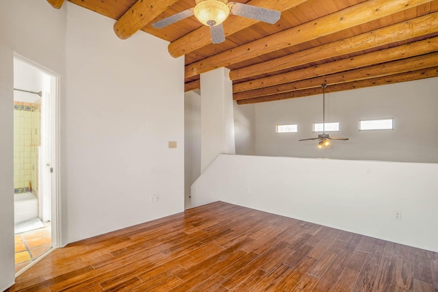 unfurnished room with wood finished floors, wood ceiling, a ceiling fan, and beamed ceiling