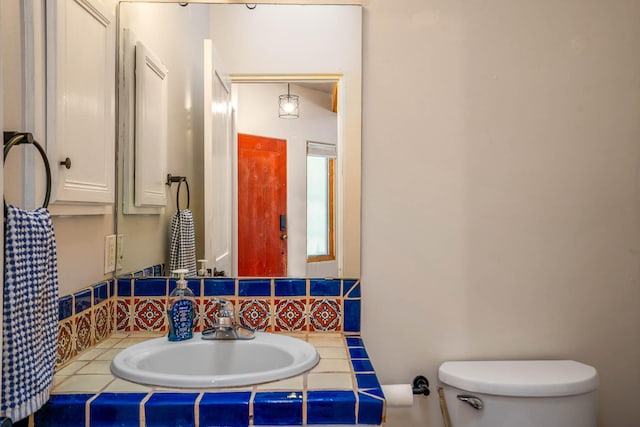 bathroom with vanity, toilet, and tasteful backsplash