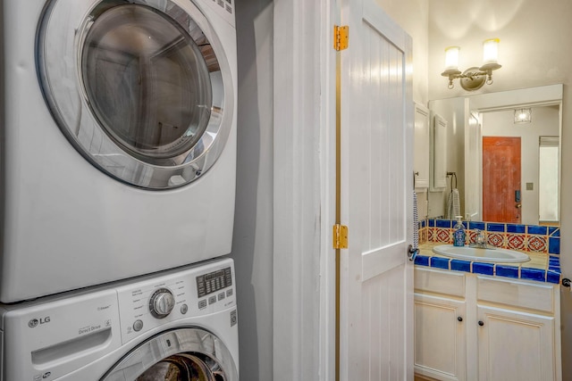 laundry area with laundry area, stacked washing maching and dryer, and a sink