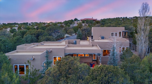 aerial view at dusk featuring a view of trees