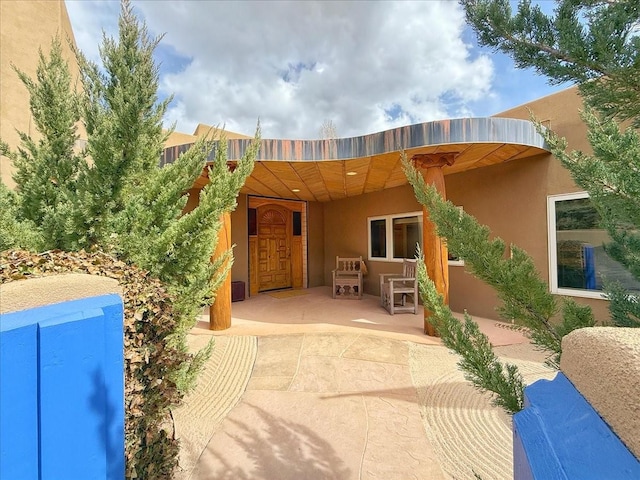 back of property featuring a patio area and stucco siding