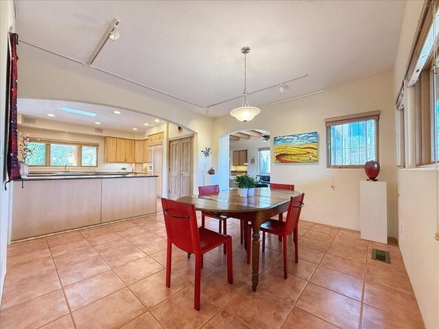 dining area featuring visible vents, light tile patterned floors, recessed lighting, rail lighting, and arched walkways