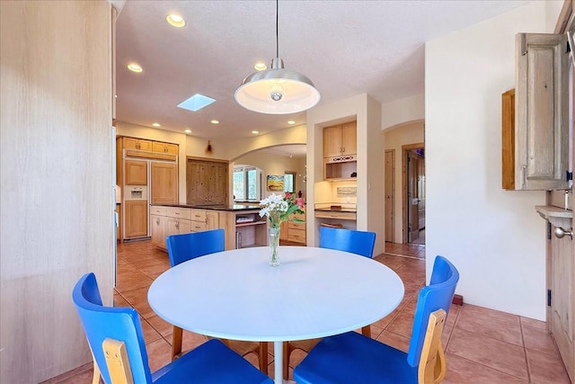 dining area with light tile patterned flooring, recessed lighting, and arched walkways