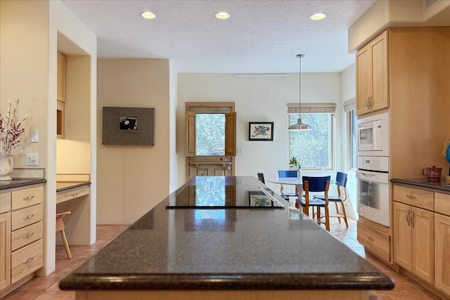 kitchen featuring a center island, light brown cabinetry, light tile patterned floors, recessed lighting, and white appliances