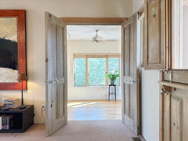 entryway with a ceiling fan, carpet, and visible vents