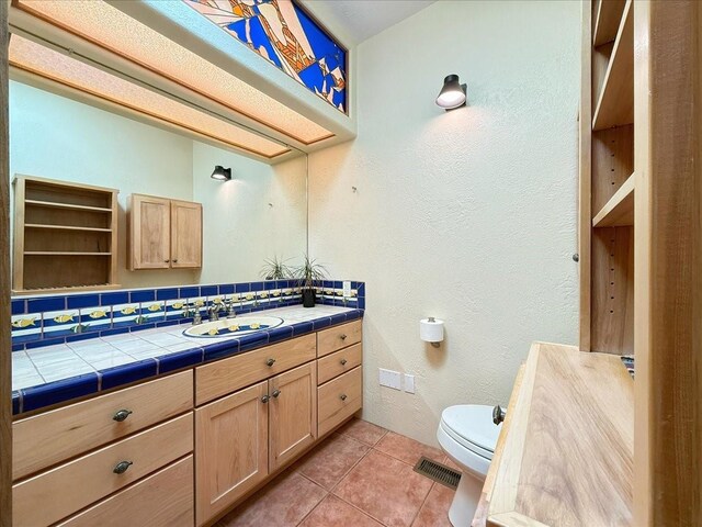 bathroom with tile patterned floors, visible vents, toilet, decorative backsplash, and vanity