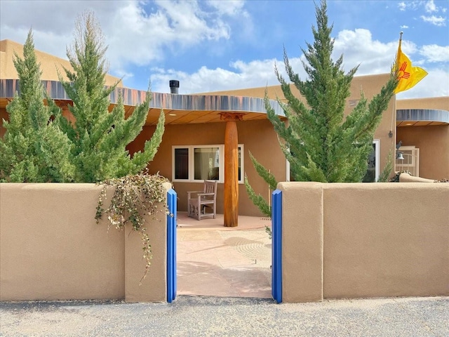 view of gate featuring a patio