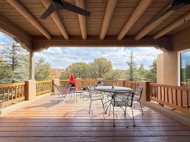 wooden terrace featuring outdoor dining area and ceiling fan