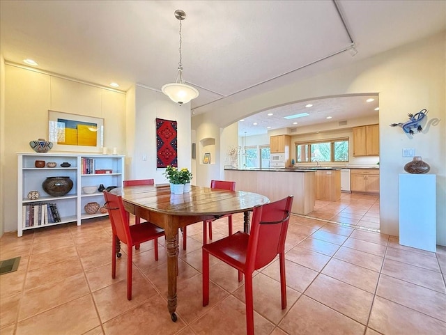 dining area with light tile patterned floors, recessed lighting, and arched walkways