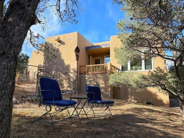 rear view of property with a patio area, stucco siding, and fence