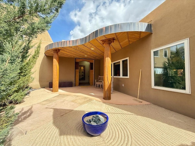 exterior space featuring a patio, visible vents, and stucco siding