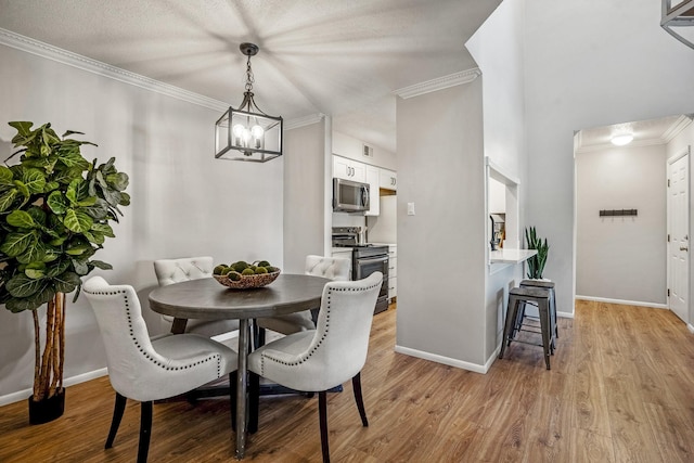 dining space with visible vents, baseboards, ornamental molding, and light wood finished floors